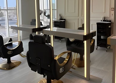 Modern salon chairs at Assort Spa & Beauty Salon, Muscat, Muscat Governorate, OM with warm lighting.