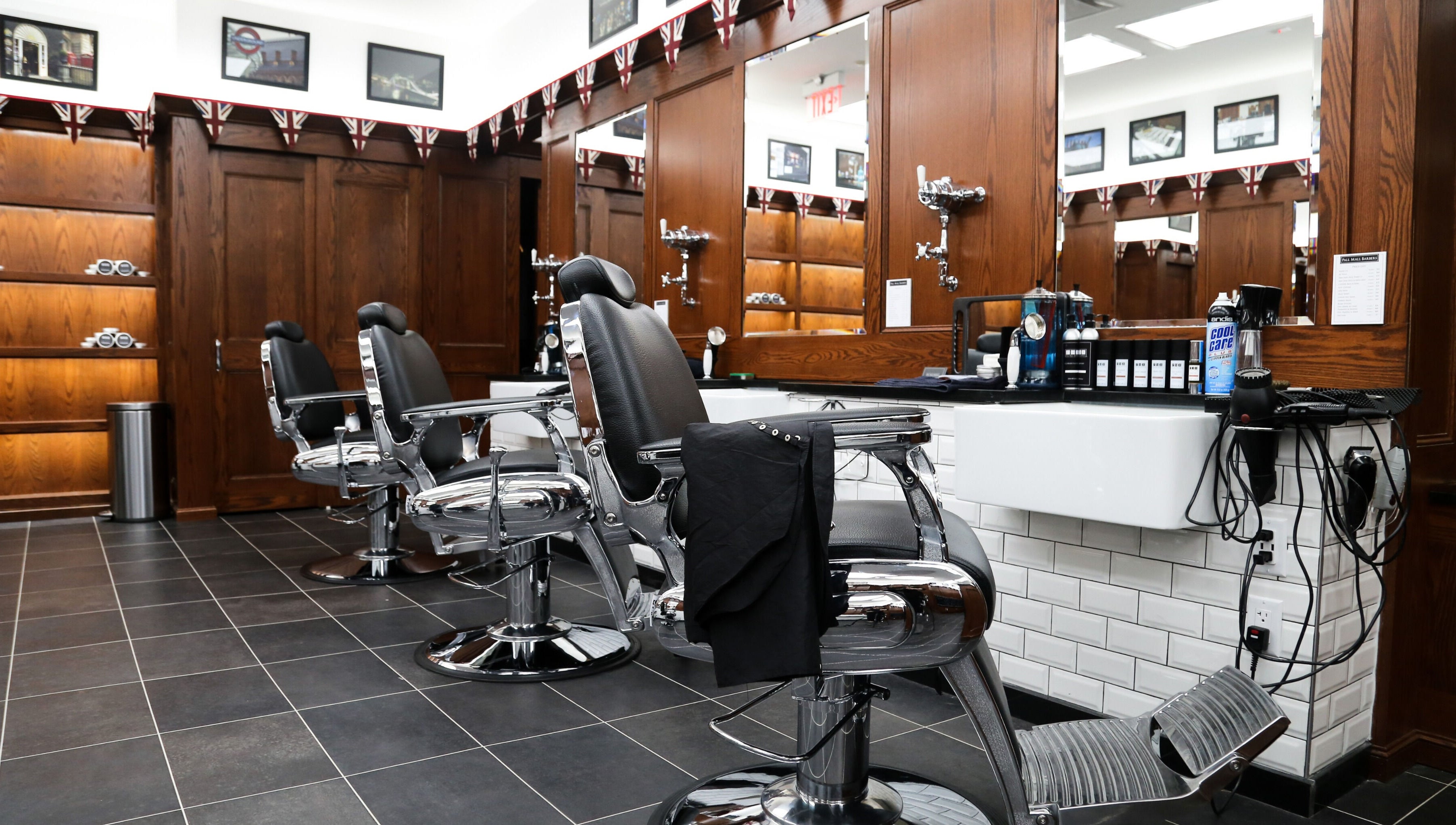Elegant interior of Pall Mall Barbers NYC in New York showing barber chairs and wooden decor.