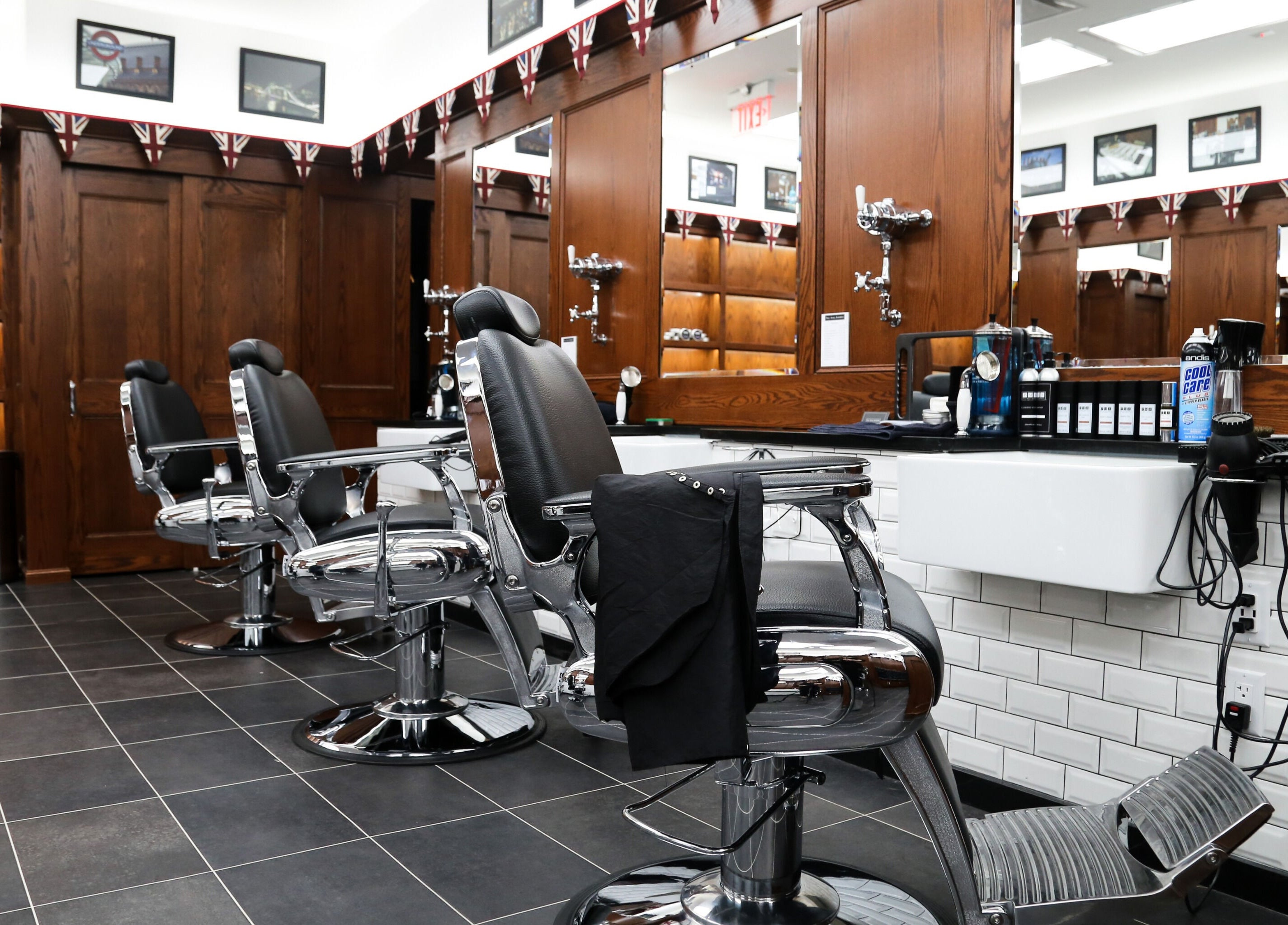 Elegant interior of Pall Mall Barbers NYC in New York showing barber chairs and wooden decor.