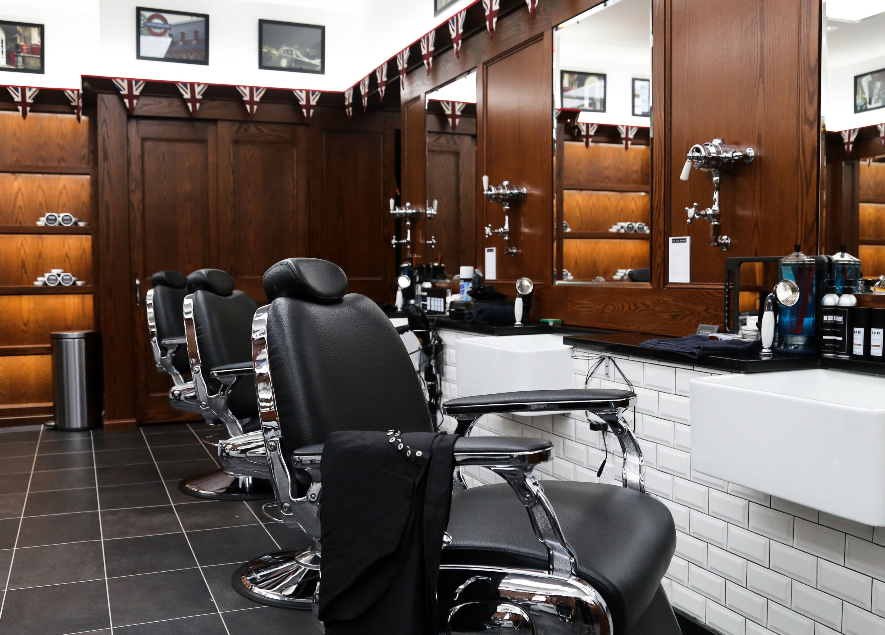 Stylish barbershop interior at Pall Mall Barbers NYC, New York, New York, US with vintage chairs and decor.