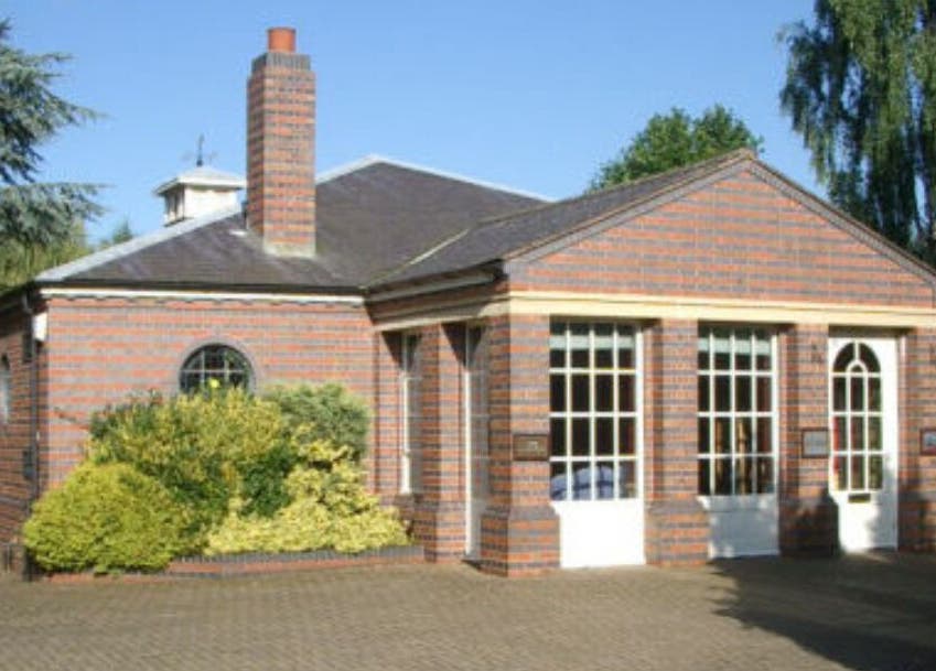 Brick building of Caroline at Ritual Therapies in Birmingham, England, GB, surrounded by lush greenery.