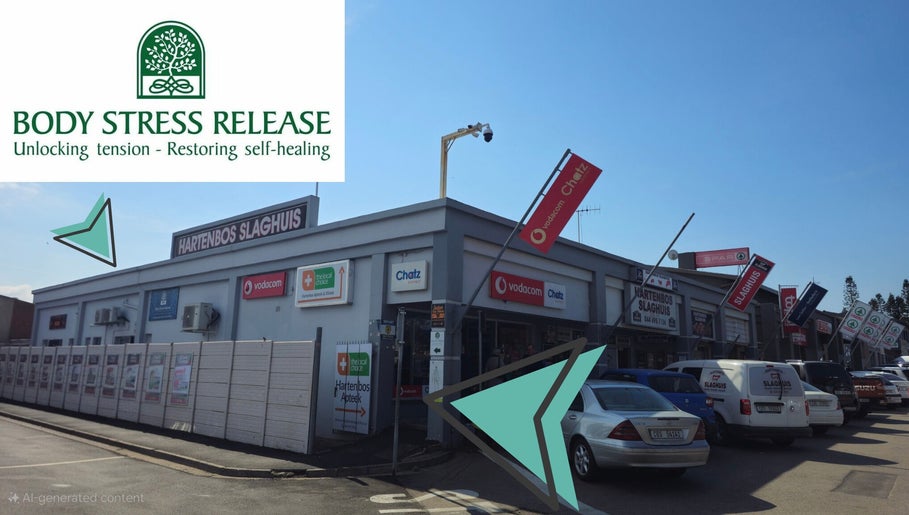Exterior of Hartenbos Body Stress Release in Mossel Bay, Western Cape, ZA, showcasing nearby businesses.