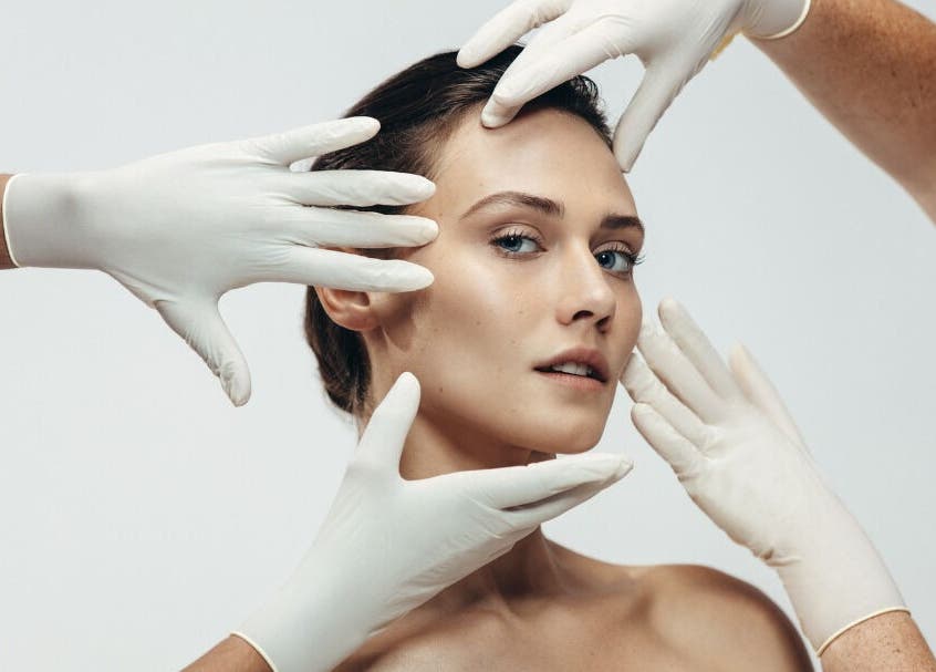 Expert skincare at Radiant Skin Aesthetics, Umhlanga, KwaZulu-Natal, ZA. Hands in gloves frame a model's face.