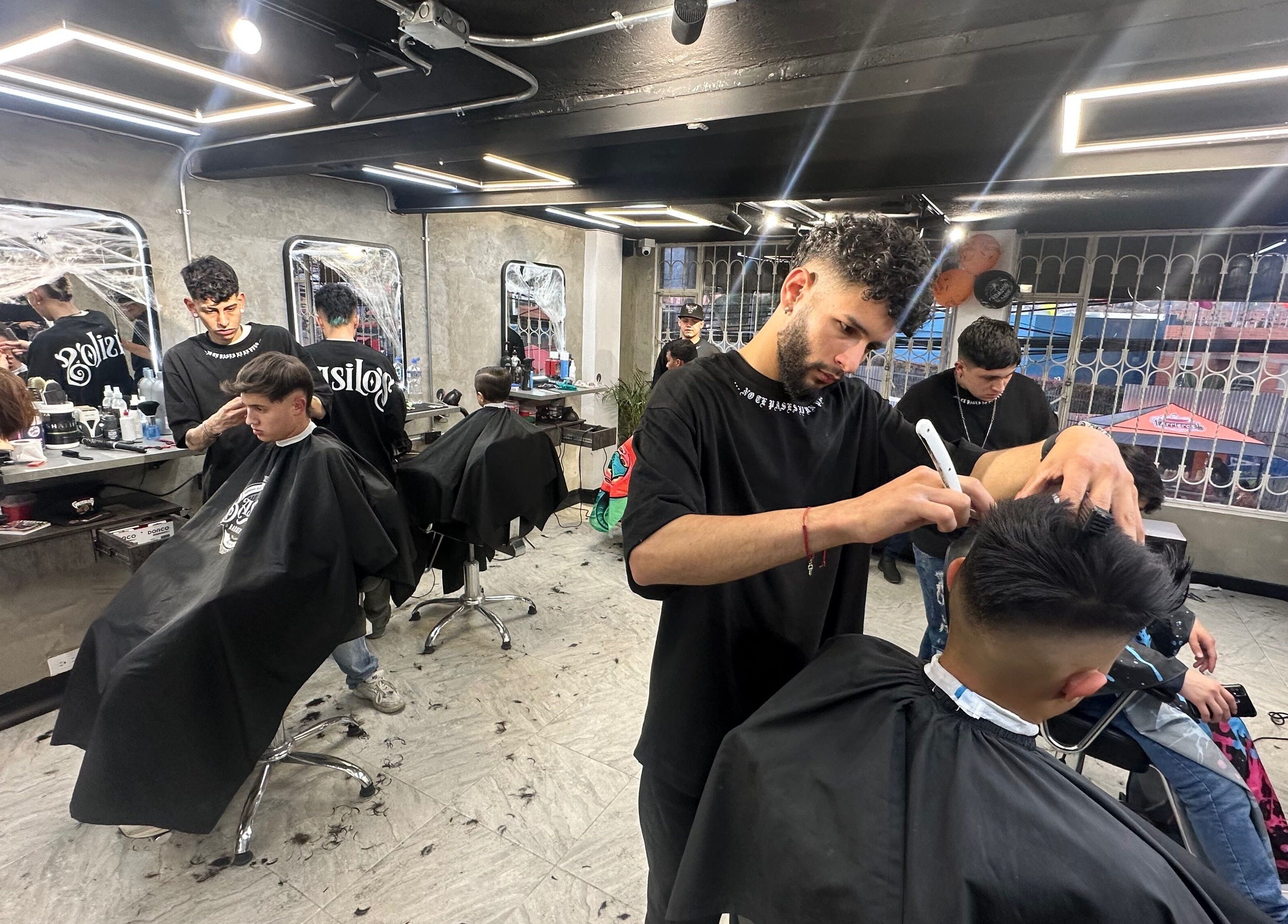 Barberos en acción en Sede Terreros, Soacha, Cundinamarca, CO, ofreciendo cortes de cabello modernos.