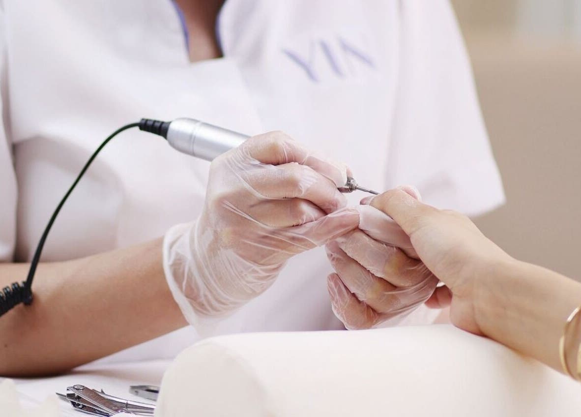Nail technician at Yin Salon and Spa in Riyadh, SA performing a professional manicure treatment.