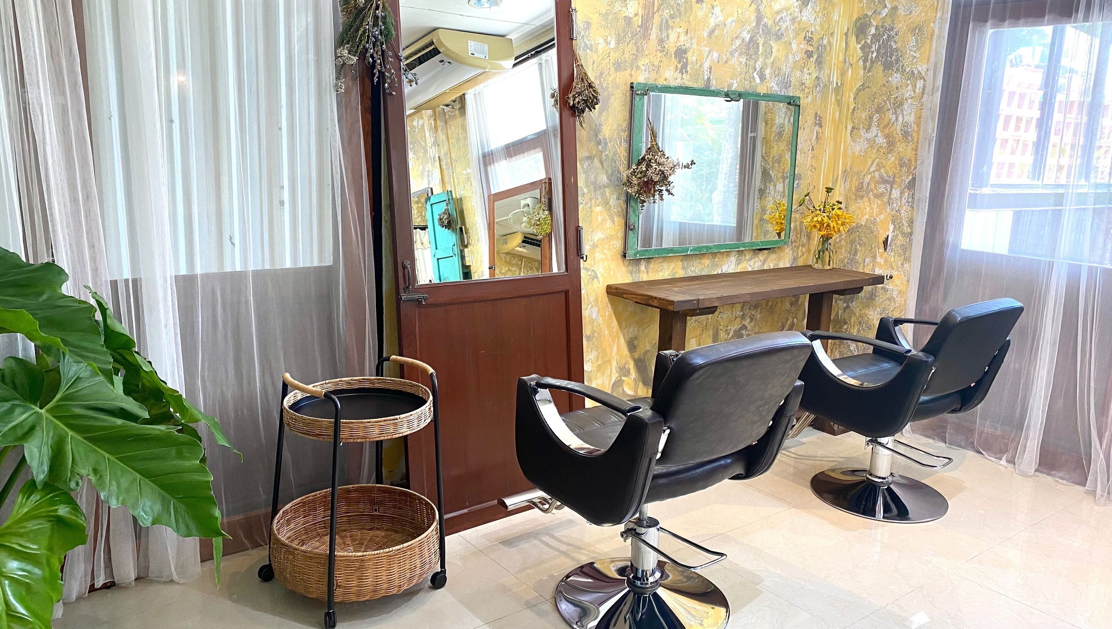 Chic interior of CUCHU Hair Design, Bangkok, TH with modern chairs and elegant décor.