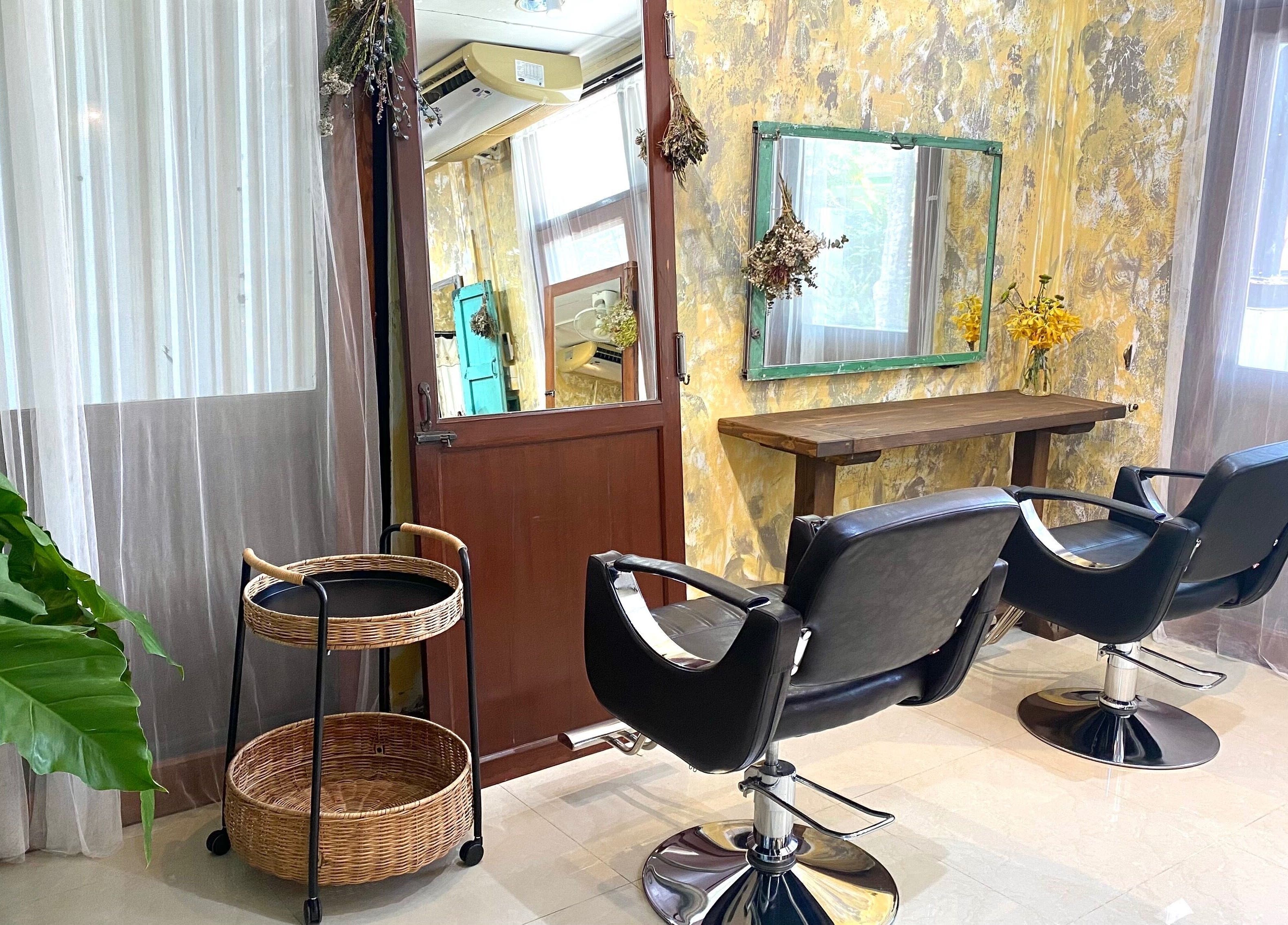 Chic interior of CUCHU Hair Design, Bangkok, TH with modern chairs and elegant décor.