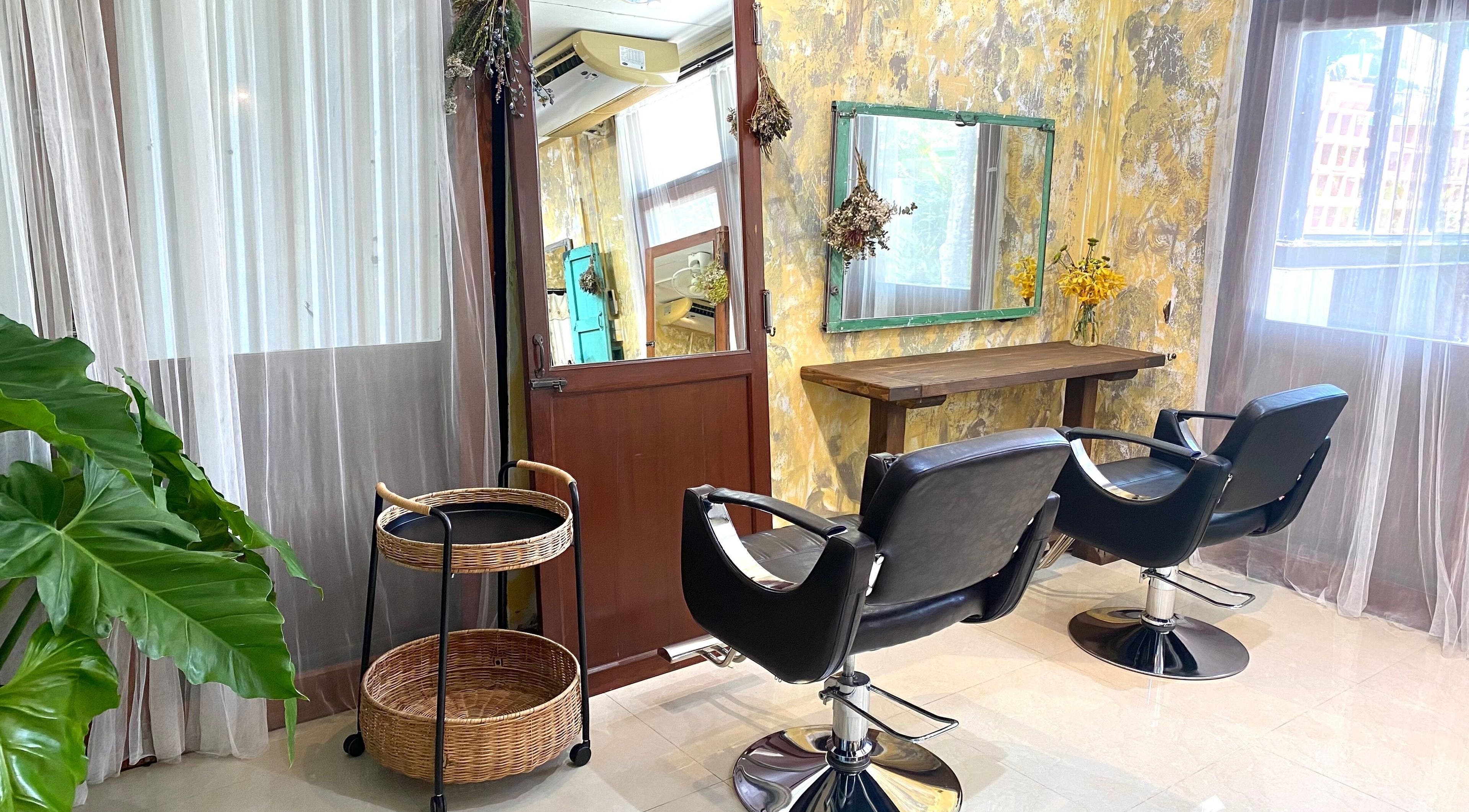 Chic interior of CUCHU Hair Design, Bangkok, TH with modern chairs and elegant décor.