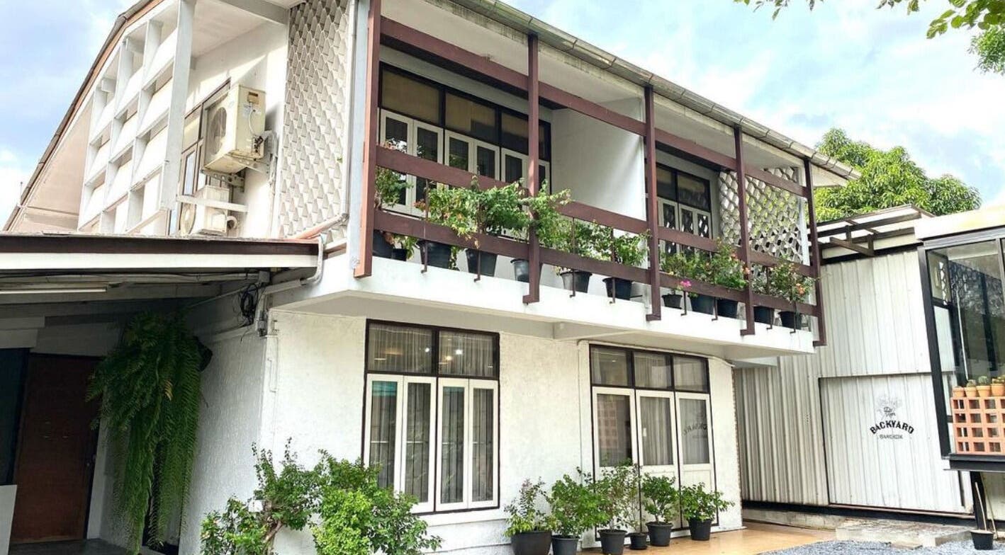 CUCHU Hair Design's stylish exterior with lush greenery in Bangkok, TH, showcasing elegance and charm.