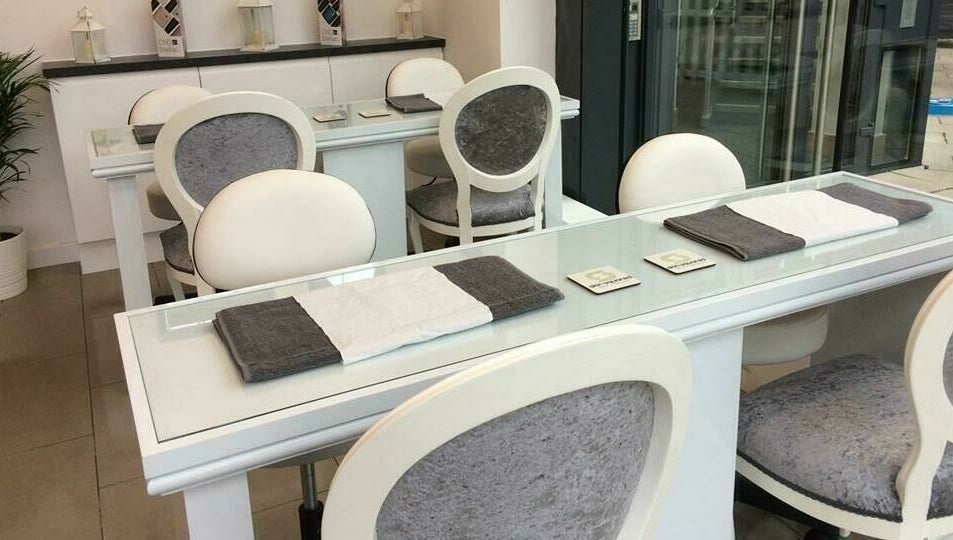 Elegant nail salon setup at Skin Squared, Whiteley, England, GB with plush chairs and glass tables.
