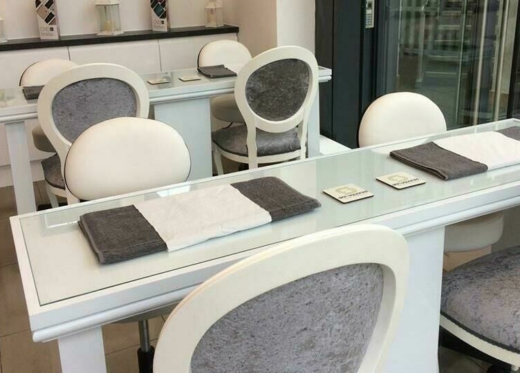 Elegant nail salon setup at Skin Squared, Whiteley, England, GB with plush chairs and glass tables.