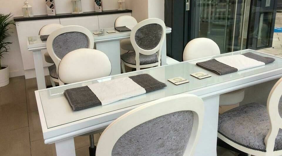 Elegant nail salon setup at Skin Squared, Whiteley, England, GB with plush chairs and glass tables.