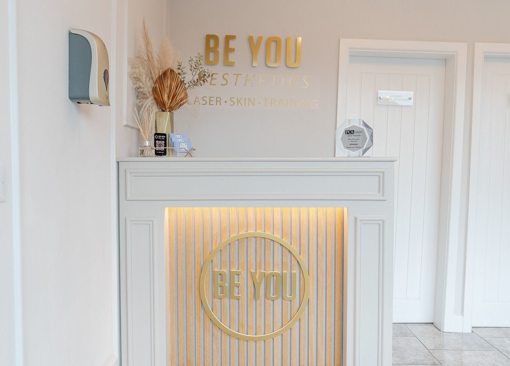 Reception area of Be You Leeds, featuring elegant decor and award display. Located in Leeds, England, GB.
