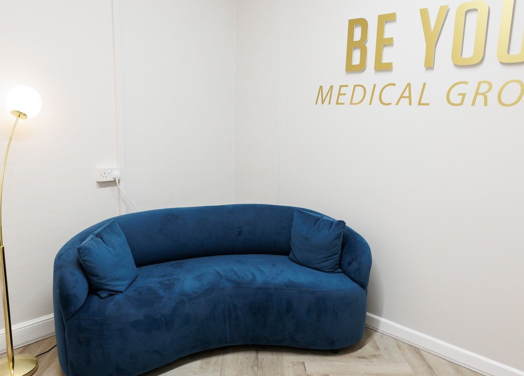 Cozy blue sofa with floor lamp at Be You Wetherby, Wetherby, England, GB. Inviting and stylish decor.