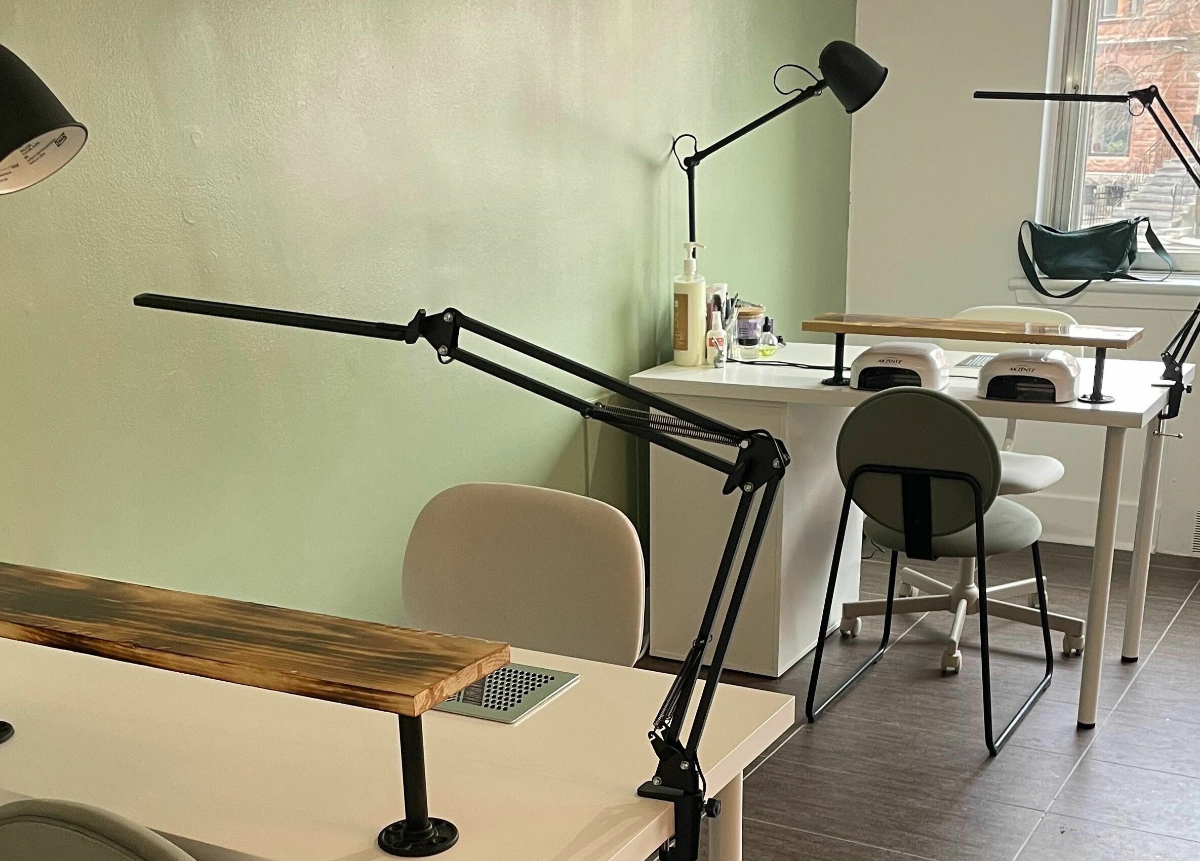 Elegant nail workstations in Studio Kay Belle, Montréal, Québec, CA with modern lighting and decor.
