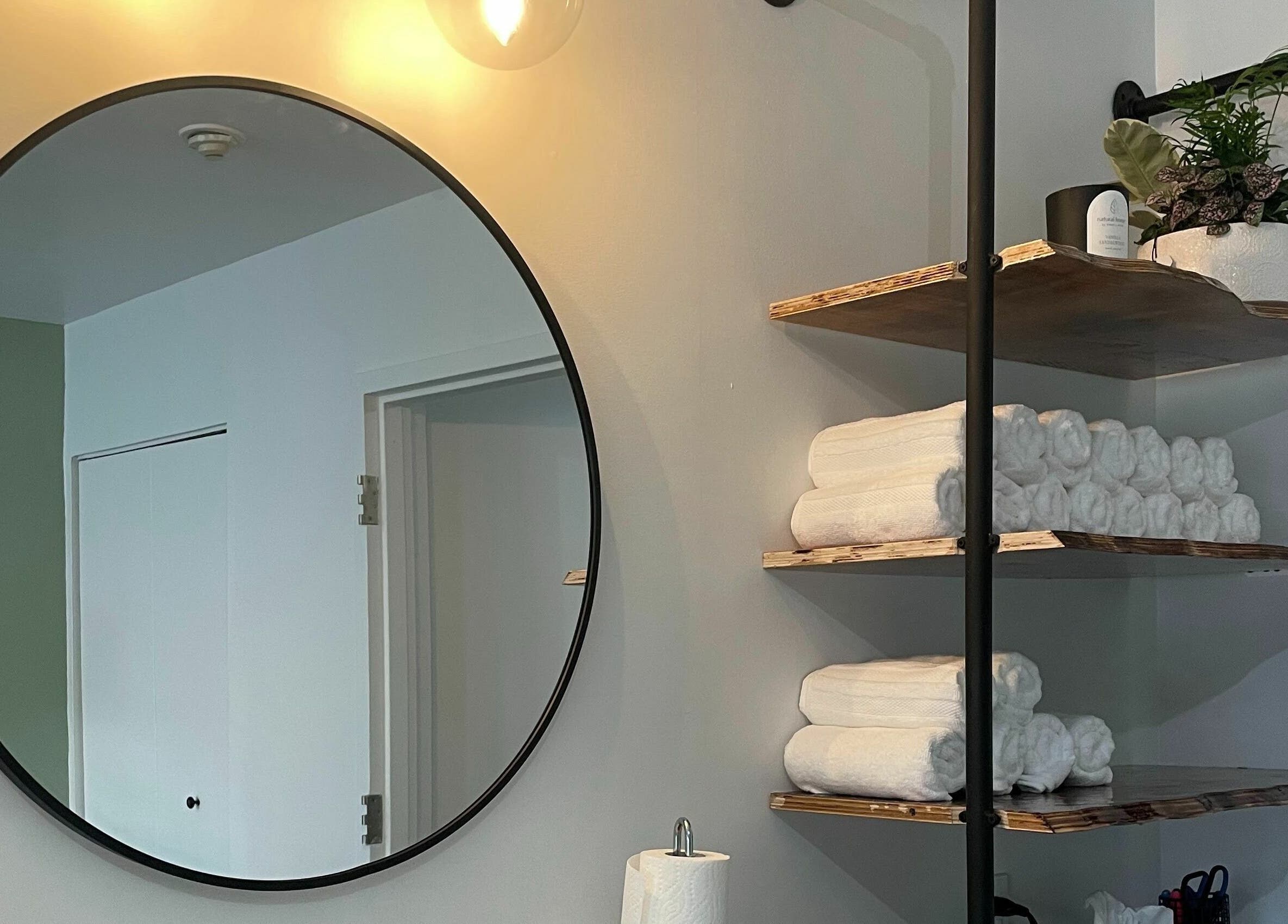 Modern round mirror and towel shelves at Studio Kay Belle, Montréal, Québec, CA.
