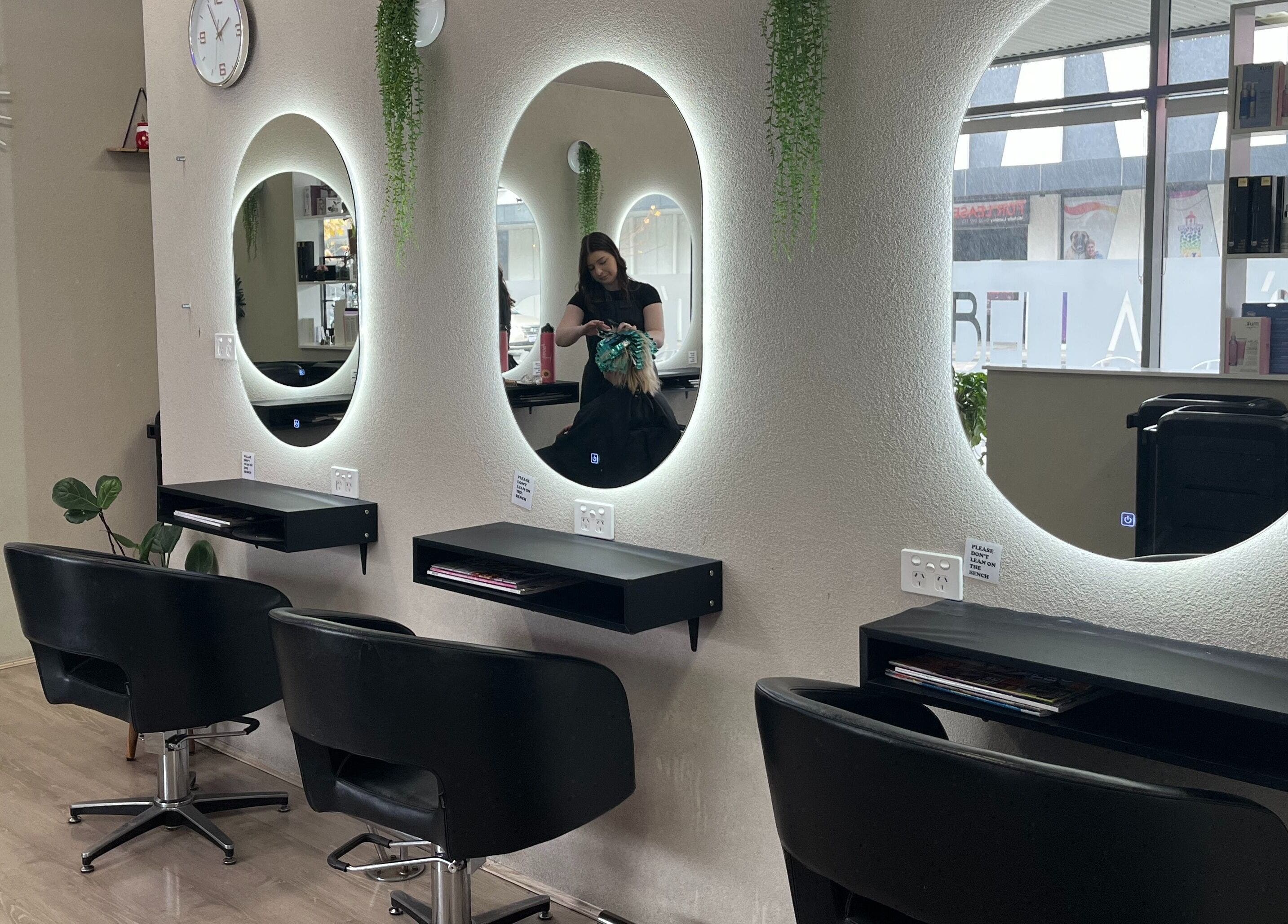 Interior view of Bella J's Unisex Hair Studio, Alkimos, Western Australia, AU, featuring stylish salon chairs and mirrors.