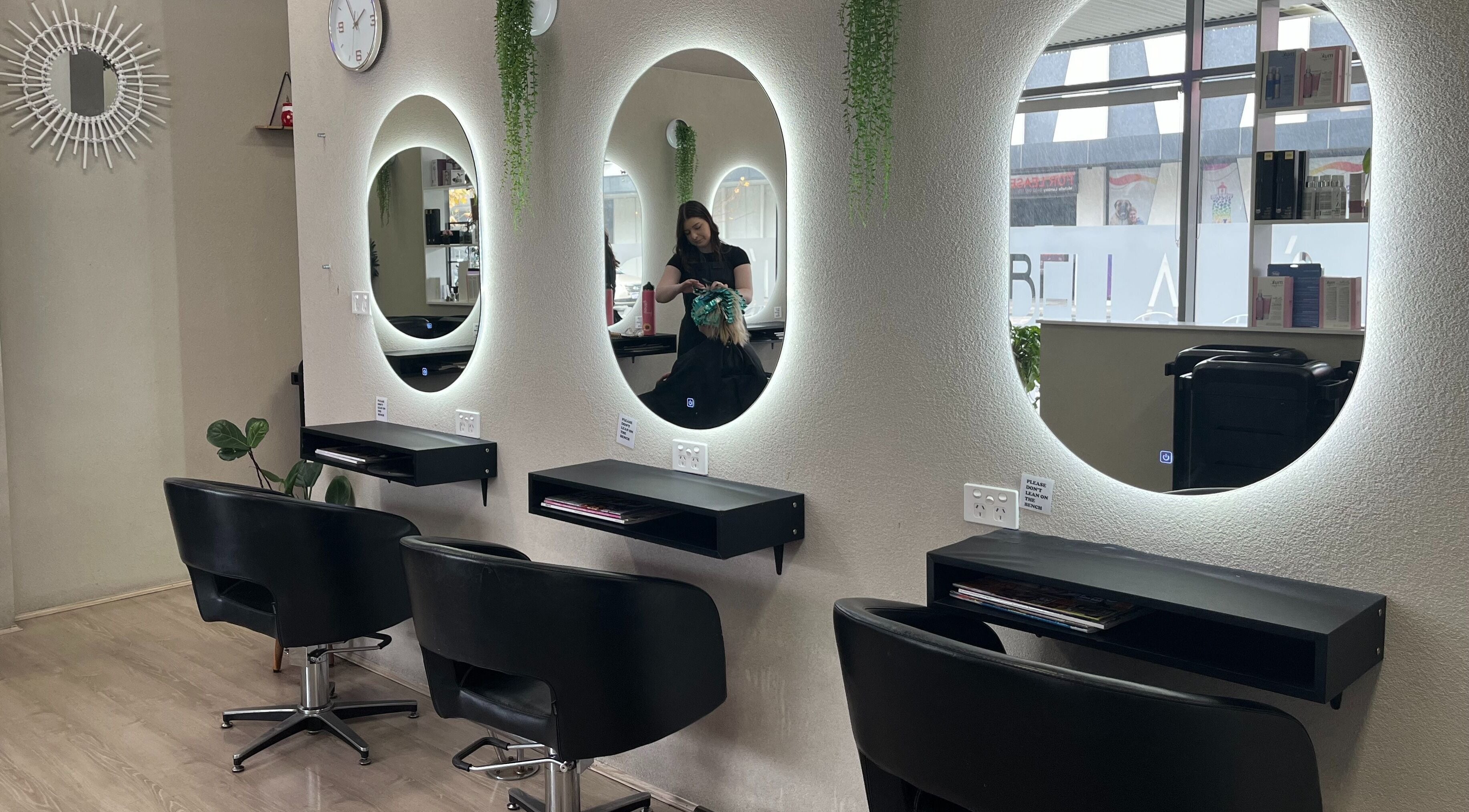 Interior view of Bella J's Unisex Hair Studio, Alkimos, Western Australia, AU, featuring stylish salon chairs and mirrors.