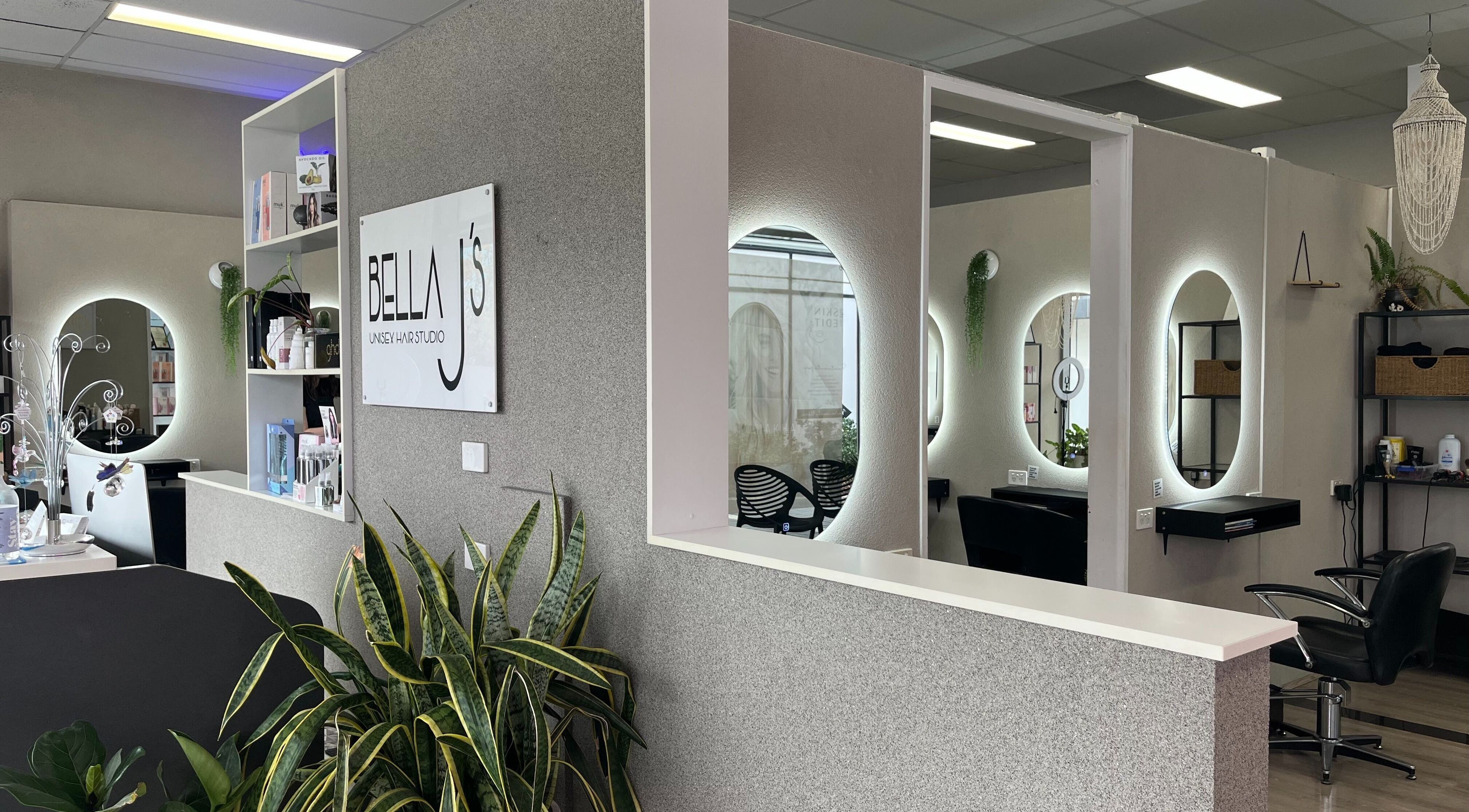 Modern interior of Bella J's Unisex Hair Studio, Alkimos, WA, featuring stylish mirrors and lush greenery.