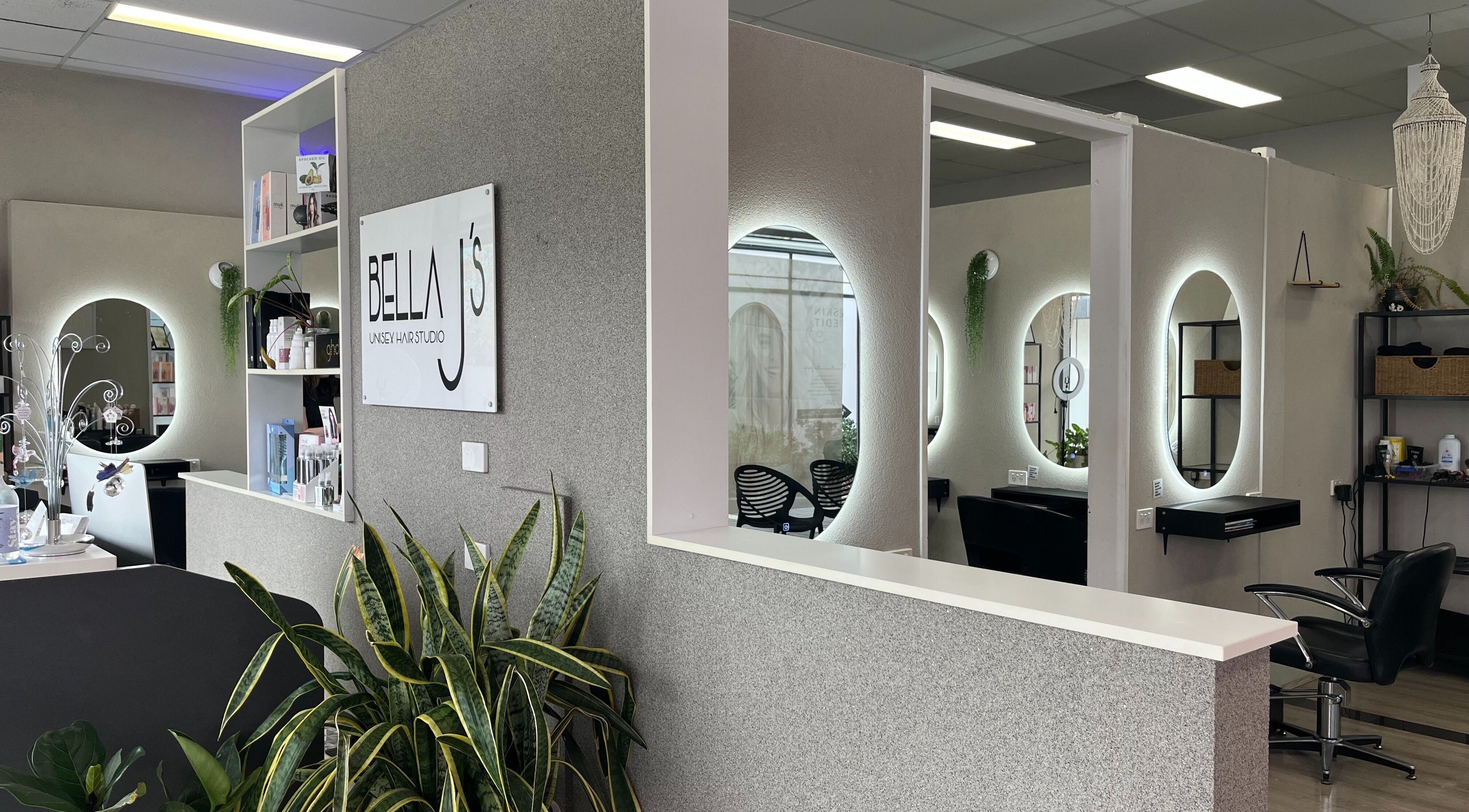 Modern interior of Bella J's Unisex Hair Studio, Alkimos, WA, featuring stylish mirrors and lush greenery.
