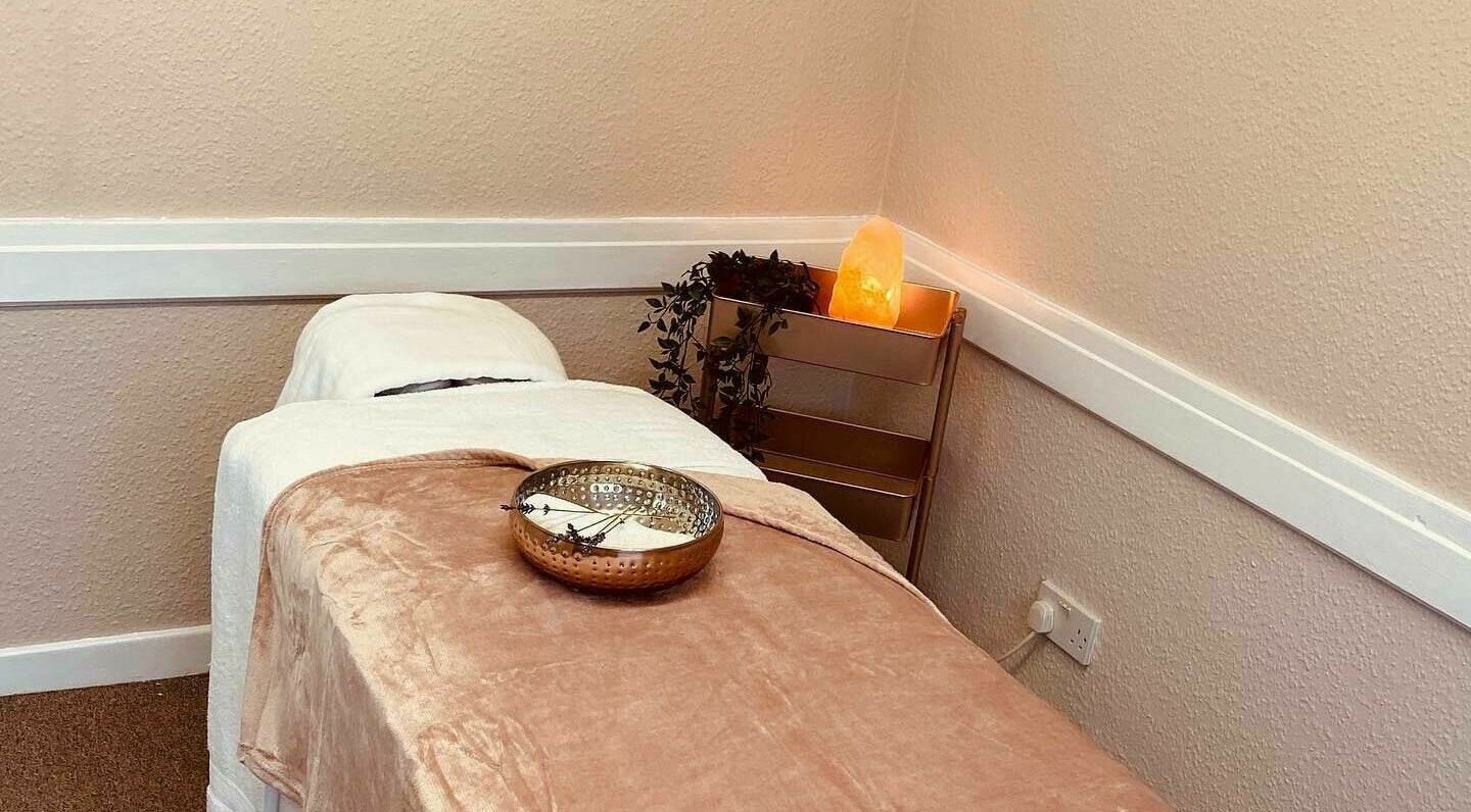 Tranquil massage bed at Katie Harwood Beauty, Broad Hinton, England, GB with soft lighting and a soothing atmosphere.