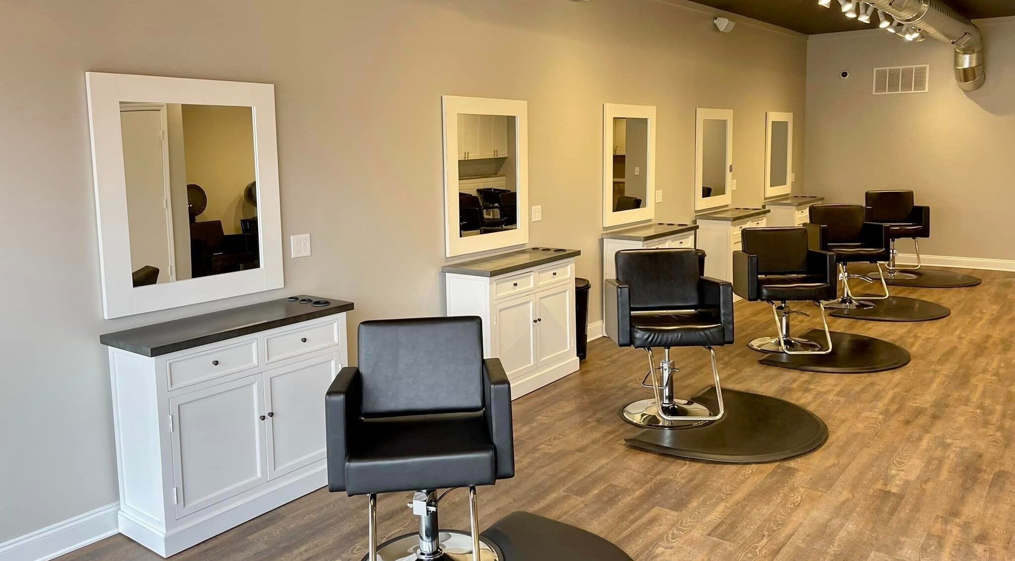 Modern styling chairs and mirrors at The Hair Lounge & Spa | Milan Michigan, a chic beauty venue in Milan, Michigan, US.