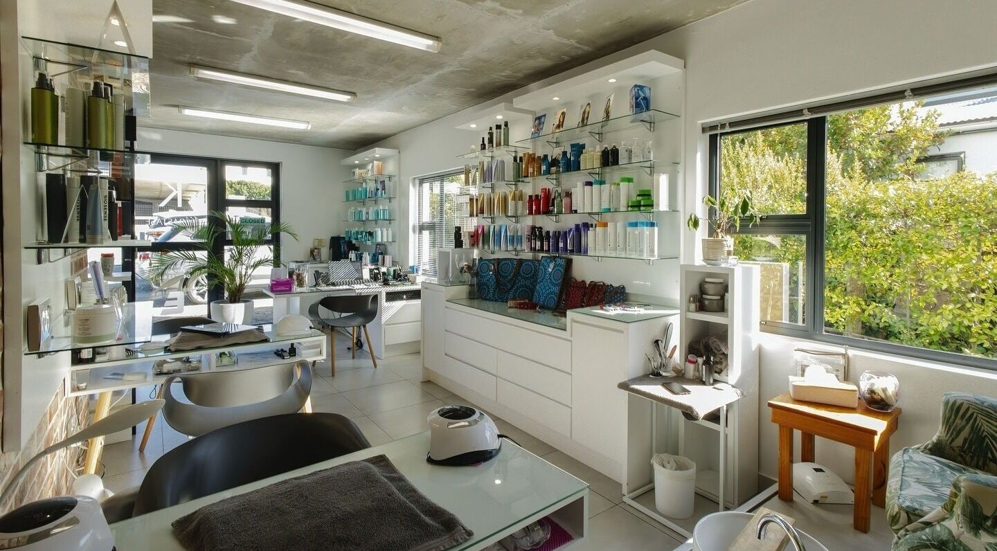 Bright, modern interior of Evolve Hair & Nails & Beauty Studio in Plettenberg Bay, Western Cape, ZA showcases beauty products.