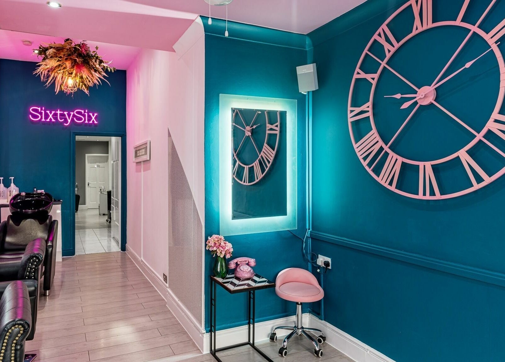 Interior of SixtySix salon in Ilford, England, GB with stylish decor and a large wall clock.