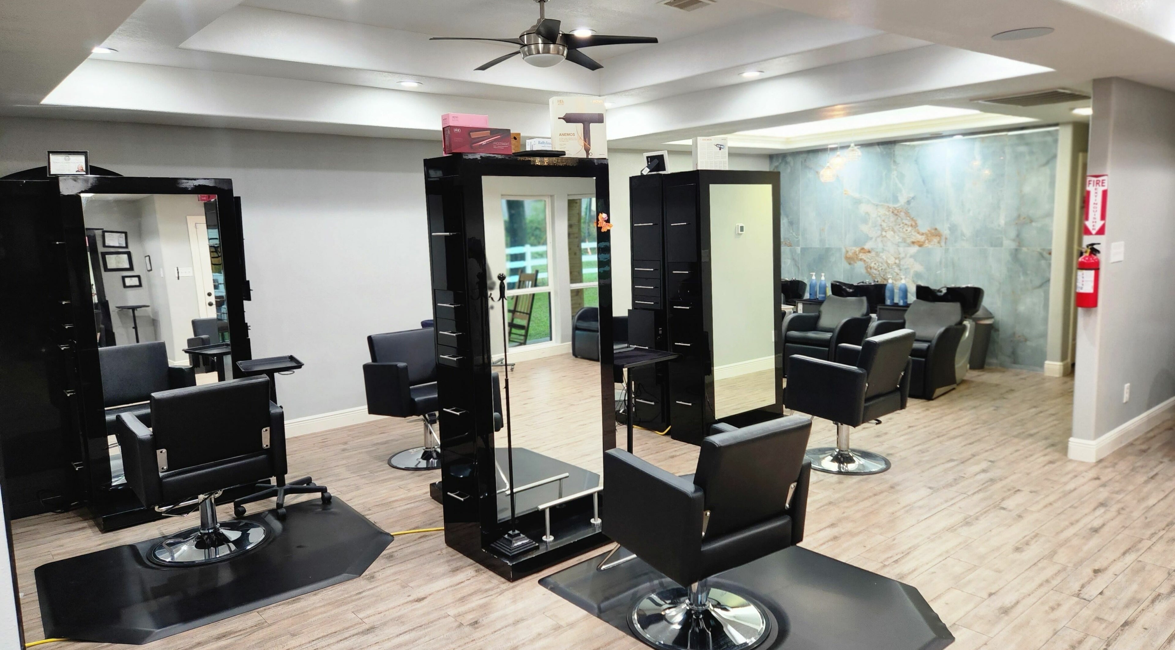 Interior of L'Shear Hair Salon in Houston, Texas, US with modern black styling chairs and sleek decor.