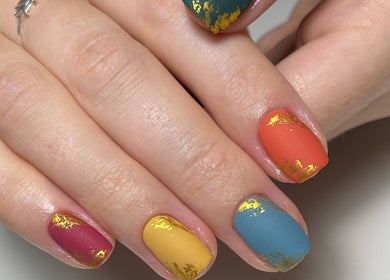Colorful nail art with gold accents at JM Nails and Beauty, Birmingham, England, GB.