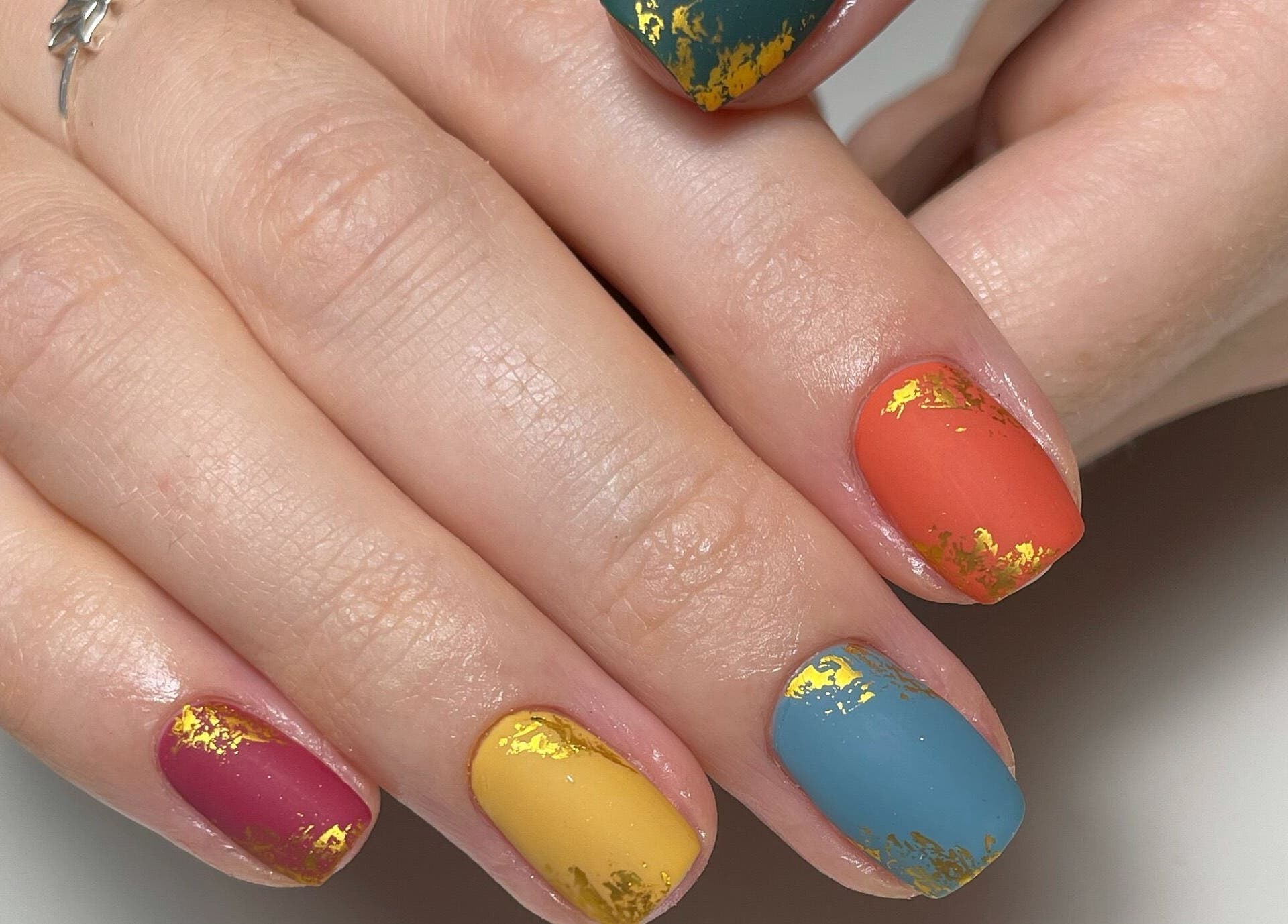 Colorful nail art with gold accents by JM Nails and Beauty, Birmingham, England, GB.