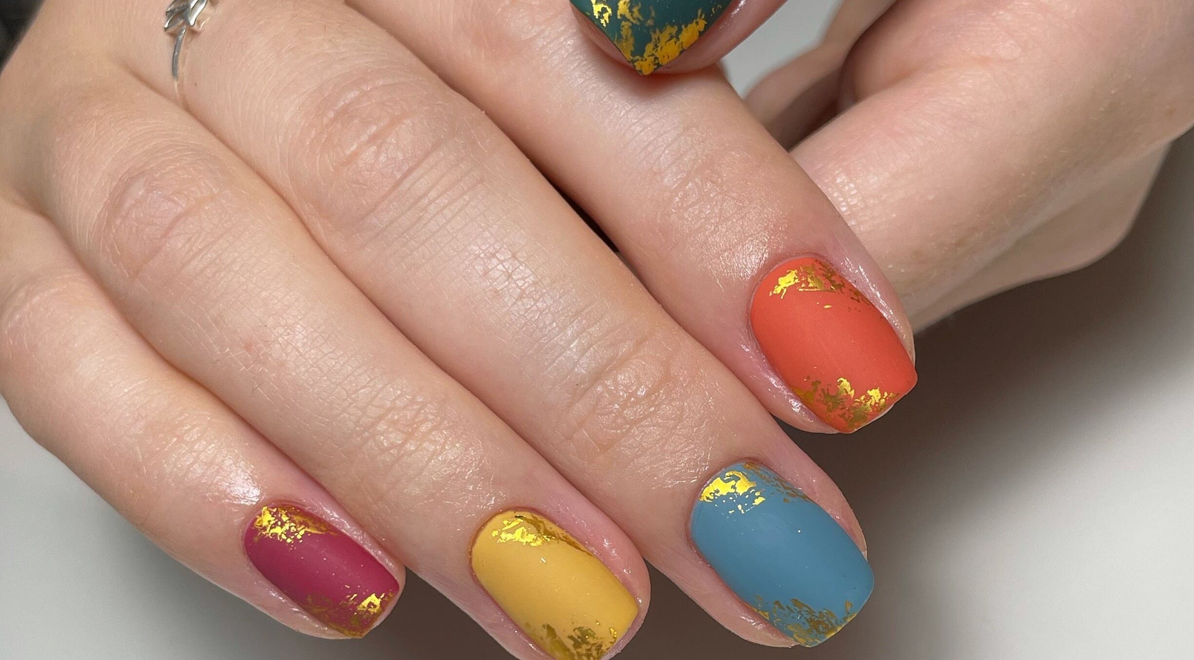 Colorful nail art with gold accents by JM Nails and Beauty, Birmingham, England, GB.