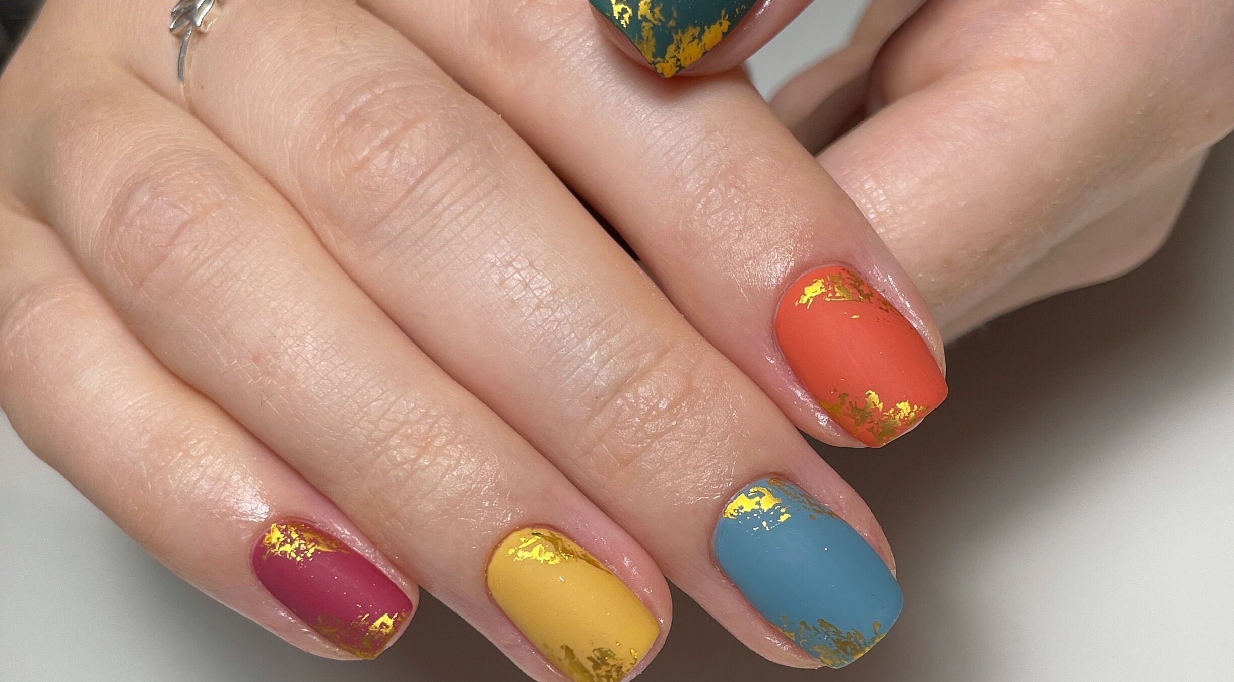 Colorful nail art with gold accents by JM Nails and Beauty, Birmingham, England, GB.