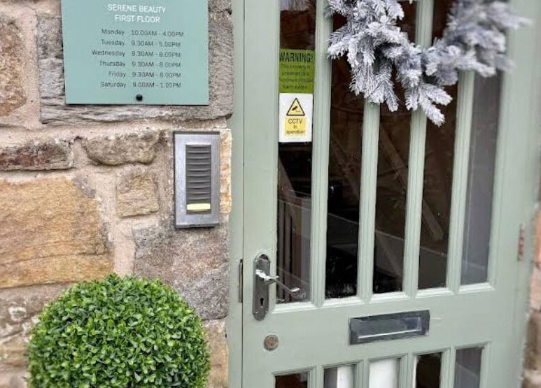 Front entrance of Dawn Furness at Okra Salon in Bedlington, England, GB featuring rustic decor and greenery.