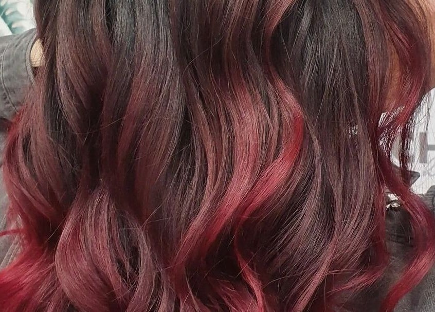 Chic red balayage hairstyle at Chloe Jade Hair, Rogerstone, Newport, GB. Vibrant and trendy salon style.