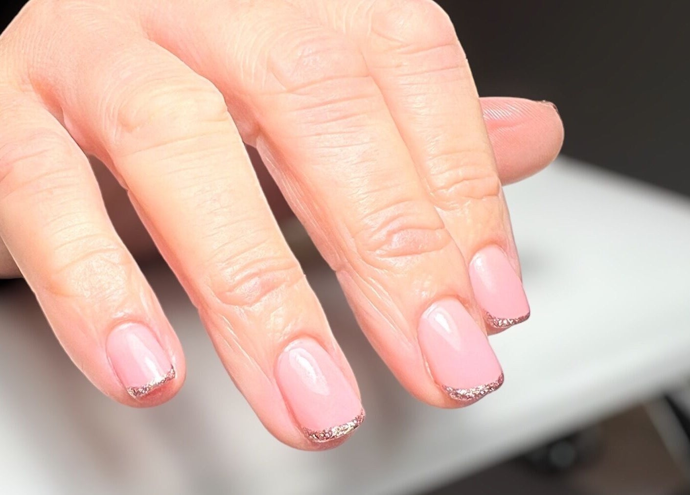 Manicured pink nails with glitter tips at Olivia’s Beauty Studio, Hockley, England, GB.