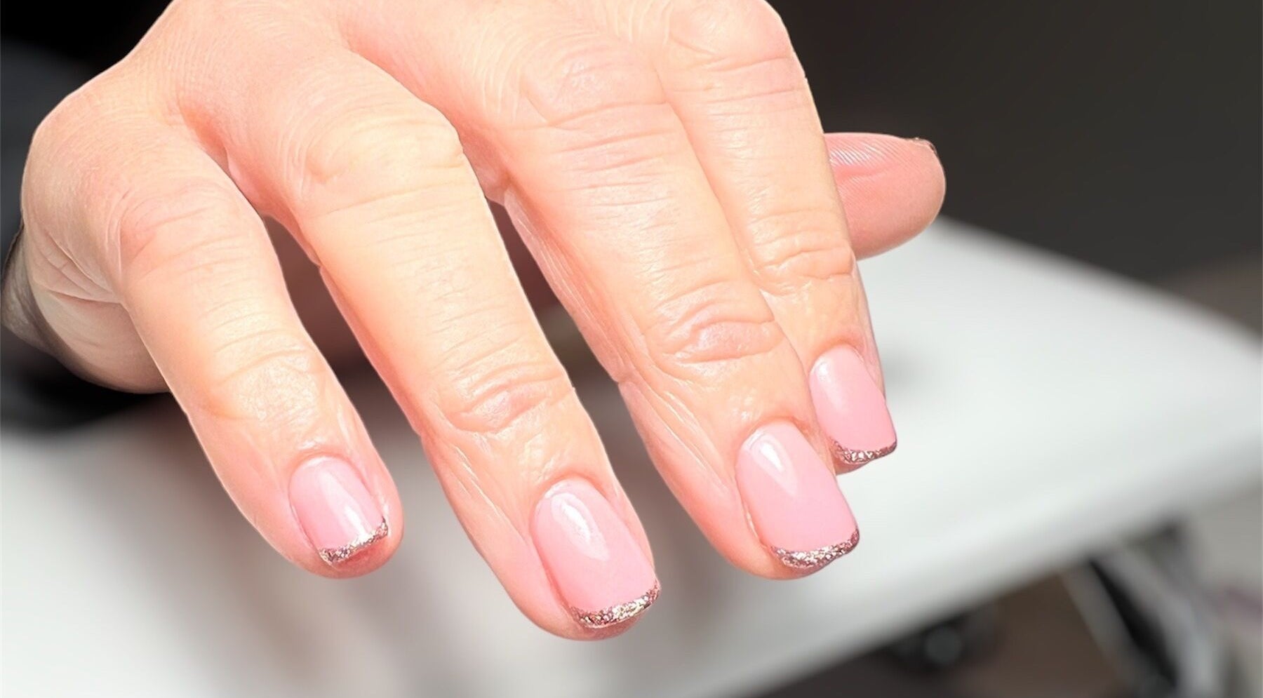 Manicured pink nails with glitter tips at Olivia’s Beauty Studio, Hockley, England, GB.