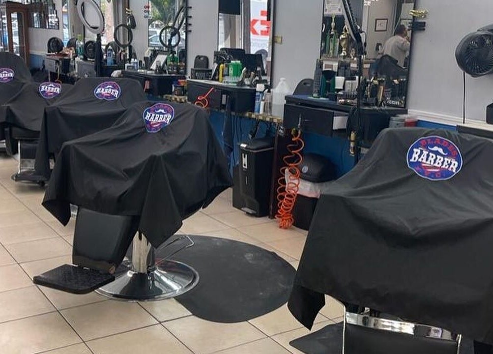 Interior de Blades Color - Tortosa mostrando sillas de barbería elegantes en Tortosa, Catalunya, ES.