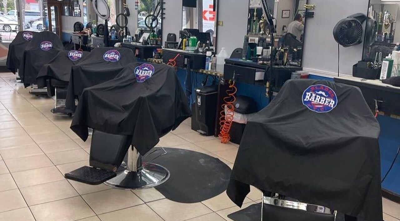 Interior de Blades Color - Tortosa mostrando sillas de barbería elegantes en Tortosa, Catalunya, ES.