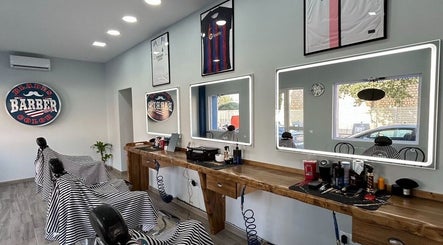 Interior moderno de la barbería BladesColor Reus, Reus, Catalunya, ES, con sillones y espejos iluminados.