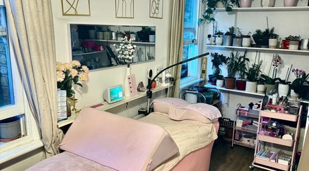 Relaxing treatment room at La Belle - Luxury Beauty by Patsy, London, England, GB, adorned with plants and soft hues.