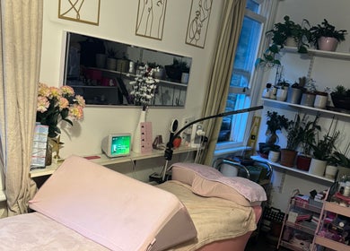 Cozy treatment room at La Belle - Luxury Beauty by Patsy in London, England, GB, featuring lush plants and elegant decor.