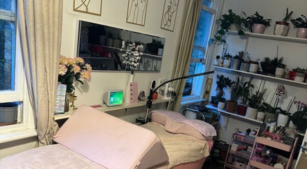 Cozy treatment room at La Belle - Luxury Beauty by Patsy in London, England, GB, featuring lush plants and elegant decor.
