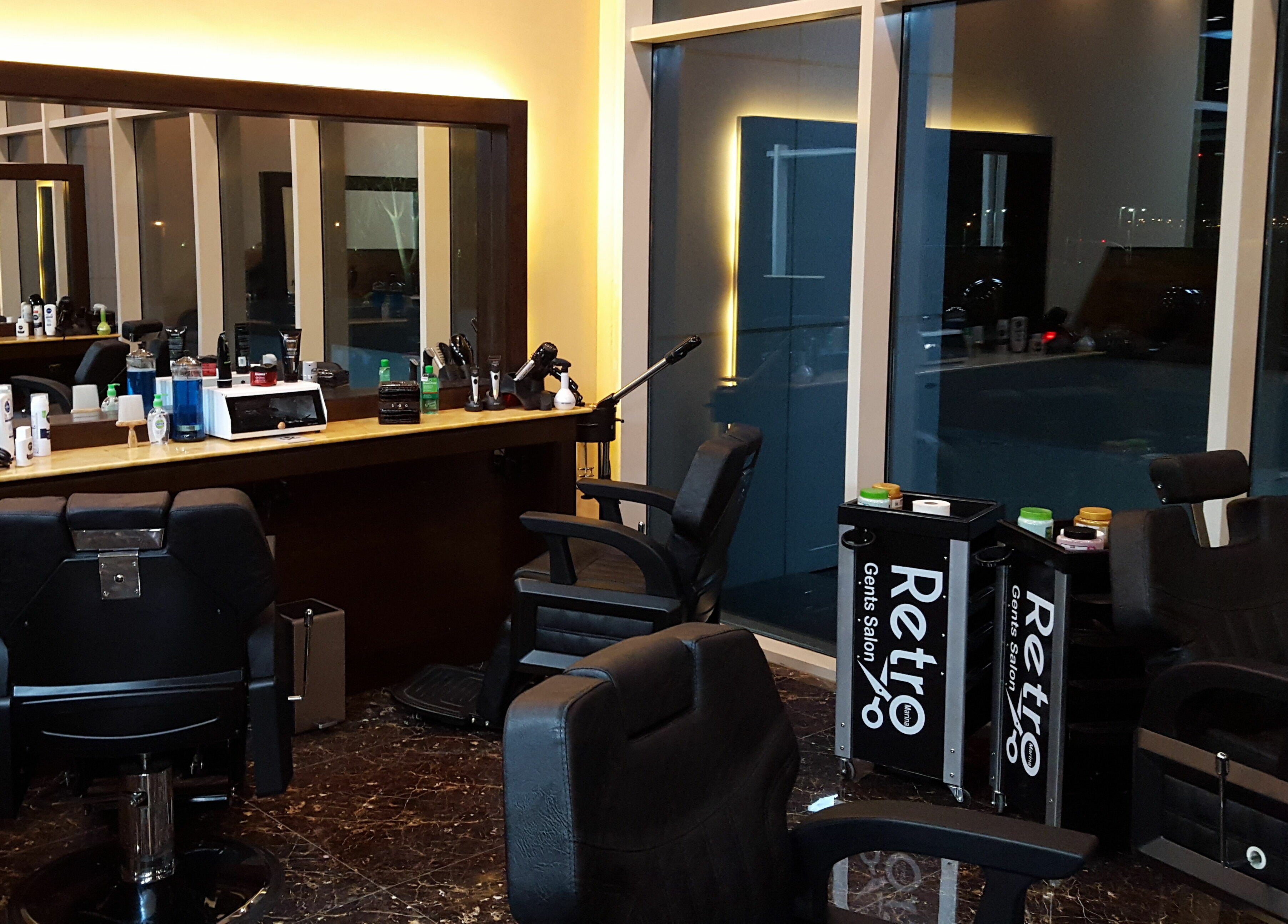 Interior of Retro Marina Gents Salon in Abu Dhabi, AE featuring modern barber chairs and stylish decor.