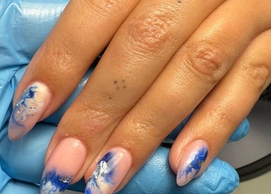 Blue marble nail art at Polished Nails, Portsmouth, England, GB. Beautifully manicured hand with intricate designs.