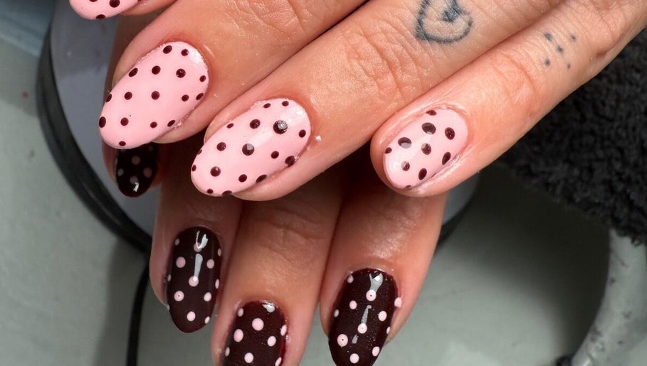 Stylish polka dot nail design at Polished Nails in Portsmouth, England, GB with pink and brown hues.