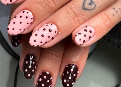Stylish polka dot nail design at Polished Nails in Portsmouth, England, GB with pink and brown hues.