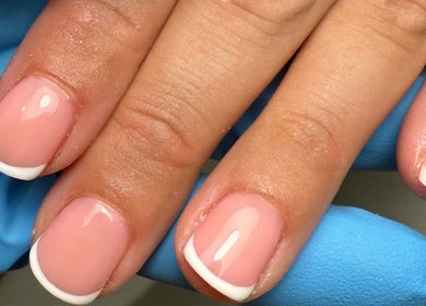 Elegant French manicure at Polished Nails, Portsmouth, England, GB, showcasing glossy finish and neat design.
