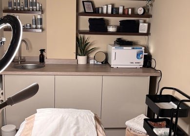 Warm, inviting treatment room at SOMA Skin Clinic, Kidderminster, England, GB, with sleek shelves and elegant decor.