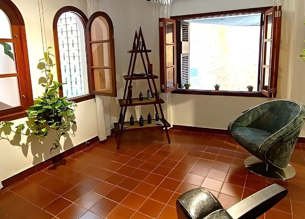 Chic, rustic interior of Barberia Santanyi Man Escape with plants and comfy chairs in Santanyí, Illes Balears, ES.